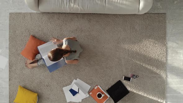 Student with a Lot of Books and Laptop Preparing for Exam at Home. 