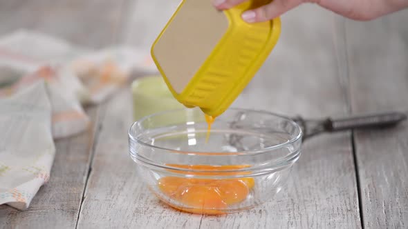 Close Up Woman Hands Beat Egg Yolks in Bowl at Kitchen