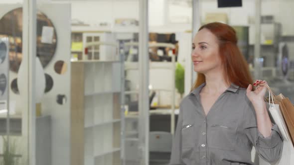 Attractive Woman Looking at the Display of a Store at the Mall