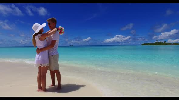 Man and woman sunbathe on marine shore beach vacation by transparent sea and white sandy background 