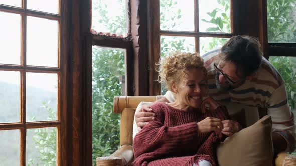 Happy adult people rural lifestyle kissing and loving each other. Woman sitting on the couch