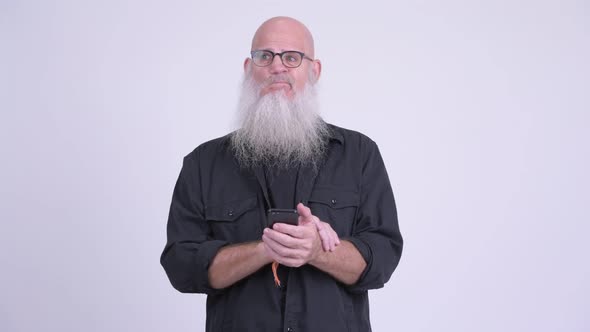 Mature Bald Bearded Man Thinking While Using Phone
