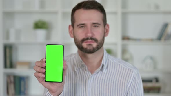 Portrait of Young Man Holding Smartphone with Chroma Screen 