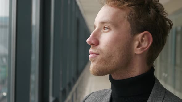 Close-up portrait of a thoughtful man looking into the distance against the city life. Profile of an