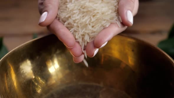 Female Hand Pouring White Brown Rice Closeup Close Up Pour Woman in Metal Bowl Before Cooking Slow