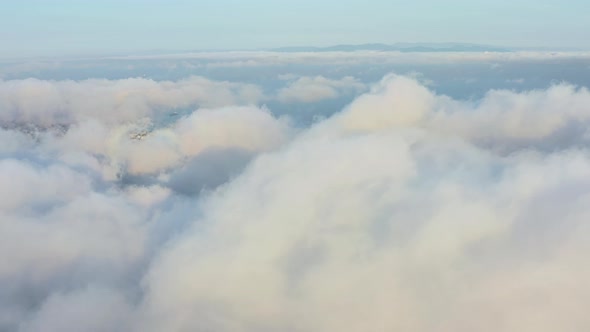 The Drone Rises From the Thick Fog Over the Beautiful Ocean of Clouds at Dawn