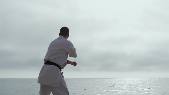 Athlete Exercising Karate Standing Ocean Beach