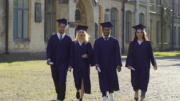 Graduates of university jumping high, happy to receive diplomas, education