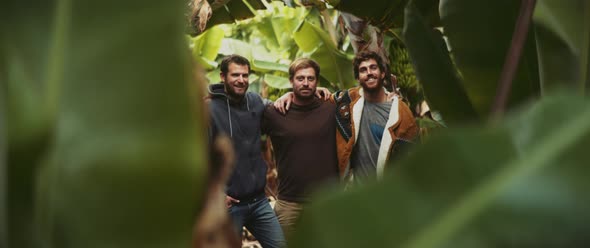 Three man standing together in banana field and smiling