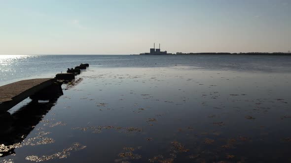 Drone flying over ocean towards Nuclear Power Plant, summertime, Sweden