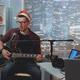 Young Vocalist in Santa Hat Singing Christmas Song Into Microphone and Playing Guitar - VideoHive Item for Sale