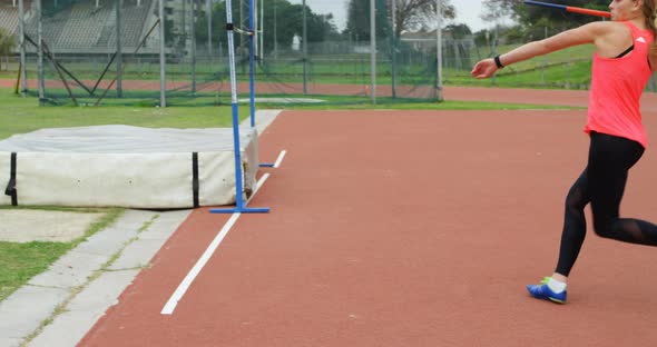 Side view of Caucasian female athlete practicing javelin throw at sports venue 4k