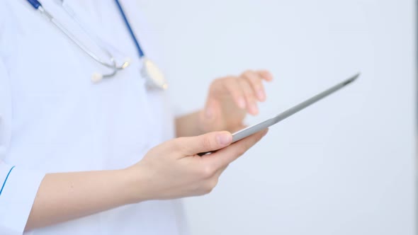 Female Doctor in White Lab Coat Using Modern Digital Tablet Pc