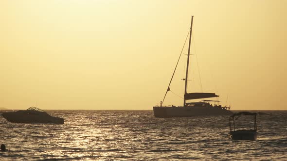 Silhouette Yacht with High Mast Sails at Sunset in the Ocean Zanzibar Africa