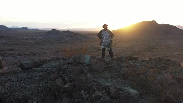 Spaghetti western hero man stands on mountain at sunset - Southwestern desert landscape - Aerial