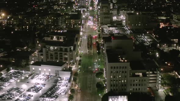 AERIAL: Flight Over Wilshire Boulevard Street in Hollywood Los Angeles at Night with View on Streets