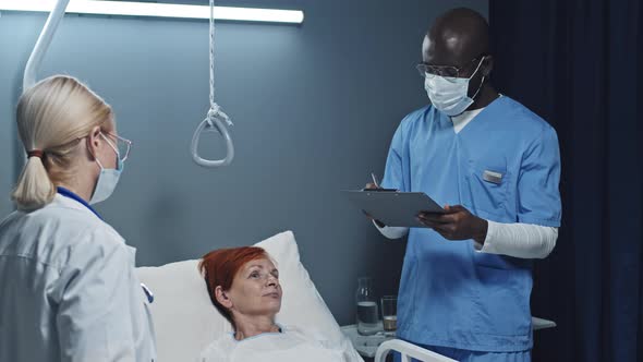 Woman Talking to Doctors in Infection Ward