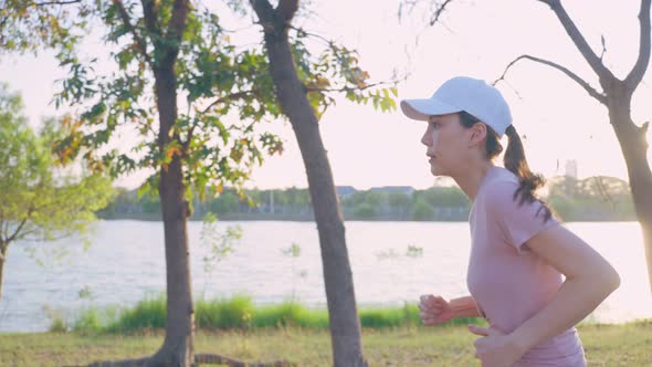 Asian young beautiful sport woman running on street in public park.