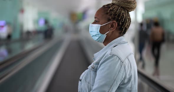 Mature african woman wearing safety face mask inside international airport