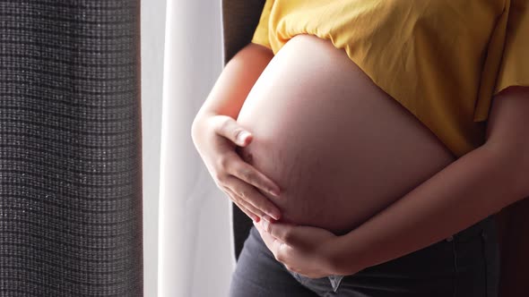 a pregnant woman holding belly