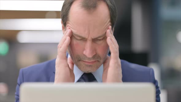 Portrait of Businessman Having Headache While Using Laptop