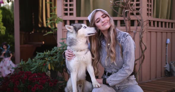 An Attractive Young Blonde Woman Play With Purebred Siberian Husky Dog In Park. Bright Sunny Day