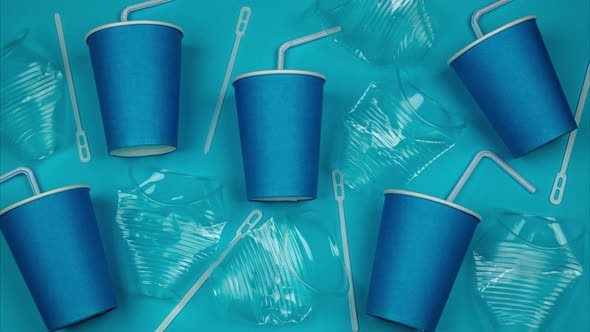 Transparent And Blue Plastic Cups And Straws Fill The Blue Background. Stop Motion