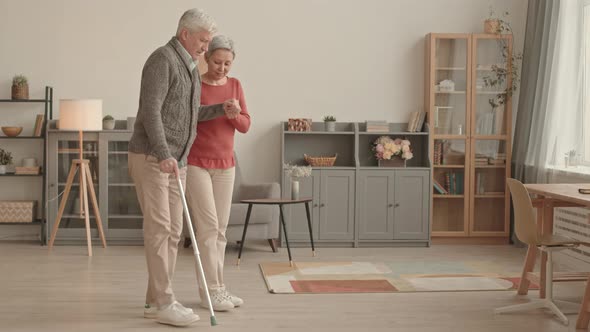 Woman Assisting Man Using Cane