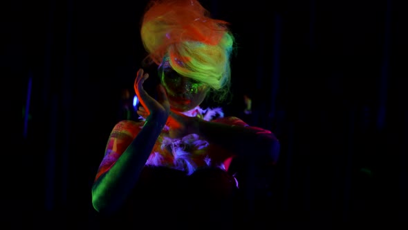 a Woman with Multicolored Hair is Dancing on a Dark Background