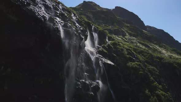 Water Flows Down the Slope of a Mountain Drops Splash From a Huge Rock