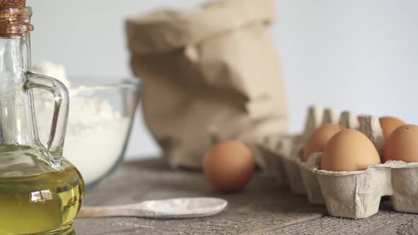 Dough preparation. Ingredients for dough Paper bag of flour, white flour in a transparent bowl, eggs