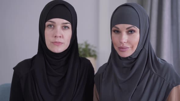 Close-up of Conservative and Modern-looking Muslim Women Looking at Camera and Smiling