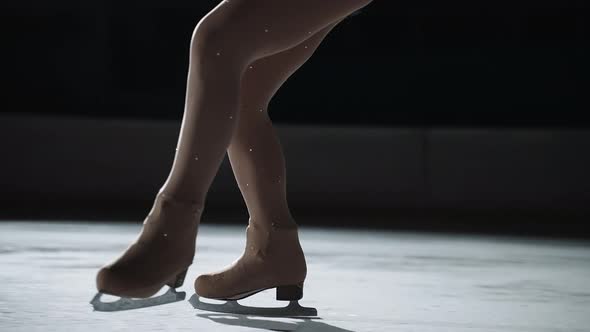 Legs of Female Figure Skater During Jumps Closeup of Skates on Ice Training or Performing Champion
