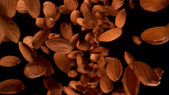 Super Slow Motion Shot of Falling Down Fresh Almonds From Behind Camera on Black at 1000Fps