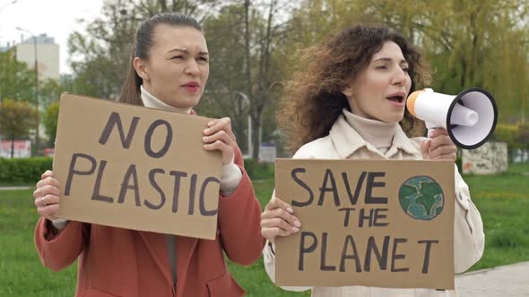 Two Women are Standing with Posters SAVE THE PLANET and NO PLASTIC