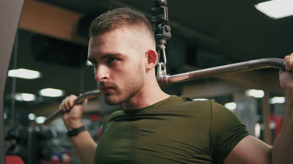 Concentrated Handsome Man Exercising His Chest Muscles and Training His Shoulders in the Gym