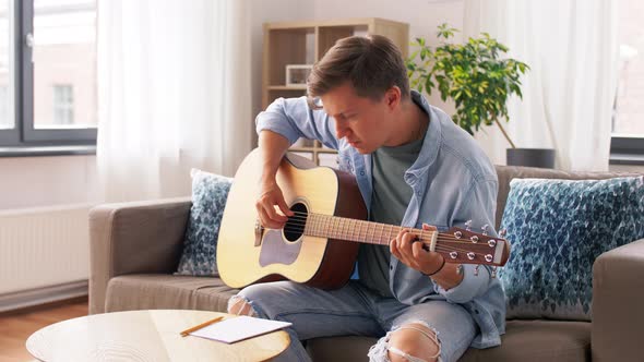 Young Man Playing Guitar at Home