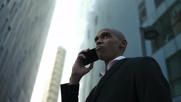 Confident African businessman talking by phone