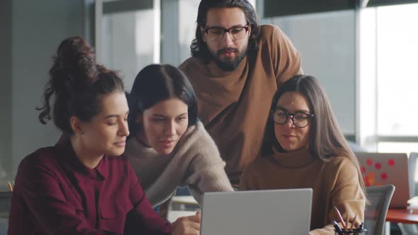 Business Team Discussing Project on Laptop