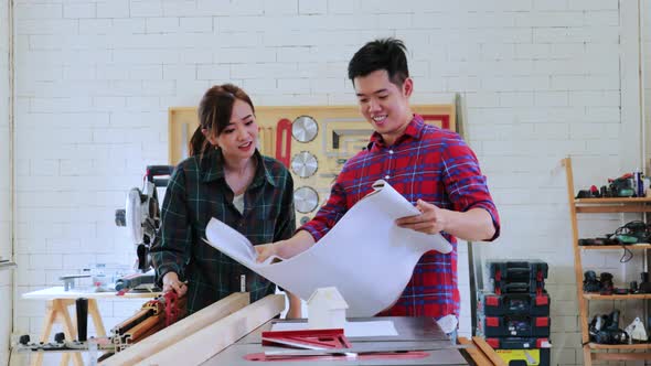 Two Carpenter students designing construction for built-in furniture project in workshop