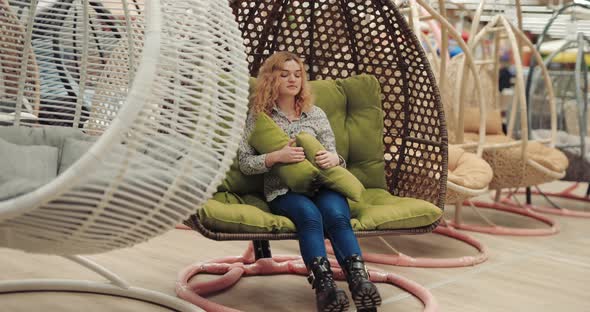 Woman Relaxing Sitting in a Cocoon Chair