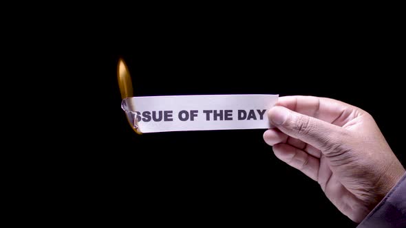 Hand Holds Paper Burning Issue Of The Day