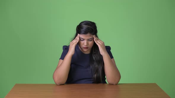 Young Overweight Beautiful Indian Businesswoman Against Green Background