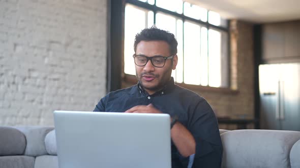 Multiethnic Hindu Freelancer Guy Using Laptop Computer for Video Call