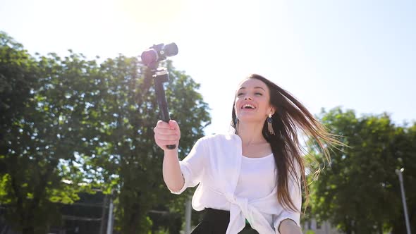 Woman Recording Video Blog On Camera On Street