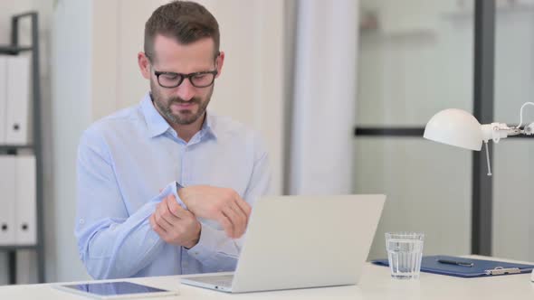 Middle Aged Man Having Wrist Pain While Working on Laptop