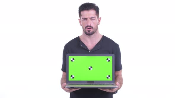 Stressed Young Bearded Man Showing Laptop