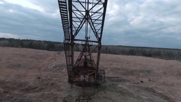 FPV Drone Flies Maneuverable Near Rusty Abandoned Walking Excavator