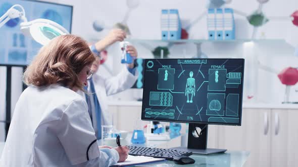 Female Scientist Taking Notes While an Advanced Scan