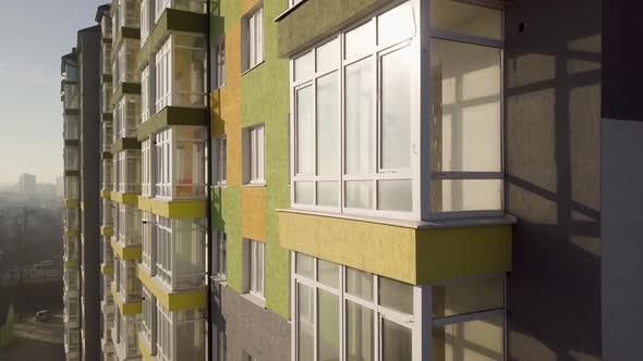 Aerial Footage of a Tall Residential Apartment Building with Many Windows and Balconies